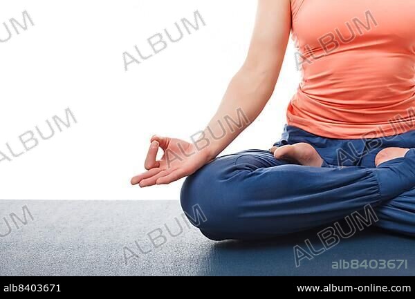 Close-up of yogini woman in yoga asana Padmasana (Lotus pose) cross legged position for meditation with Chin Mudra (psychic gesture of consciousness) . Isolated on white background with copyspace.