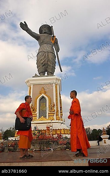 Monument of the last King Chao Anouvong in Vientiane on the Mekong River, two Buddhist monks having a chat in front of it, Laos, Southeast Asia, Asia.