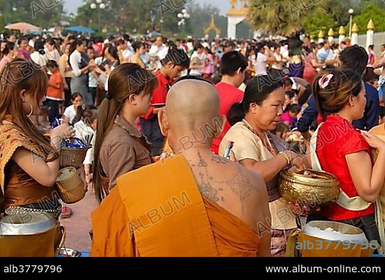 Theravada Buddhism, That Luang Festival, Tak Bat, tattoos, monk with spiritual tattoos on his back and bald head, believers, pilgrims giving alms, orange robes, Vientiane, Laos, Southeast Asia, Asia.