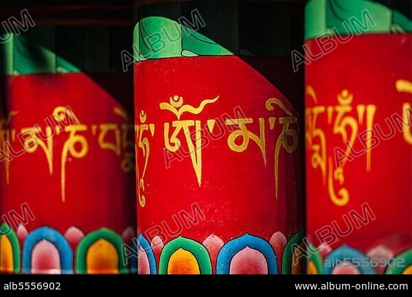 Buddhist prayer wheels with om mani padme hum (meaning The jewel is in the lotus) mantra. Kora around Tsuglagkhang complex. Mcleodganj, Himachal Pradesh, India, Asia.