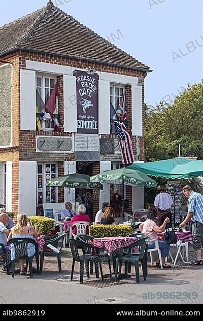 Tourists visiting the Pégasus Bridge café, first French house to be liberated during D-Day in WW2 at Bénouville, Lower Normandy, France, Europe.