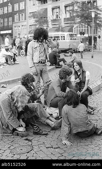 Hippies playing guitar on Dam Square, 1970s, Amsterdam, Netherlands.