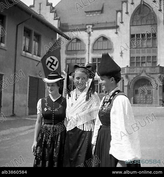 Approx. 1939,1941, women in traditional costumes posing, in the background a swastika flag, Freiburg, Germany, Europe.