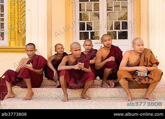 Monks sitting and resting, Mahamuni Paya, Chanmyathazi, Mandalay, Myanmar, Asia.