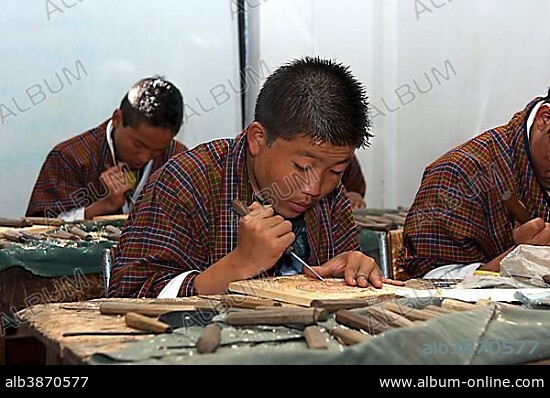 Highly concentrated students doing an apprenticeship in woodcarving at the National Institute of Traditional Arts and Crafts, Zorig Chusum, Thimphu, Bhutan, Asia.