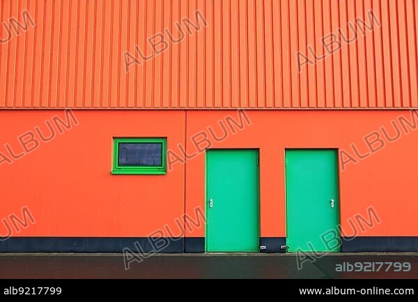 Architecture, industrial building, industrial hall with orange cladding and green door, security door, fire door Architecture, industrial building, industrial hall with orange cladding and green door, security door, fire door