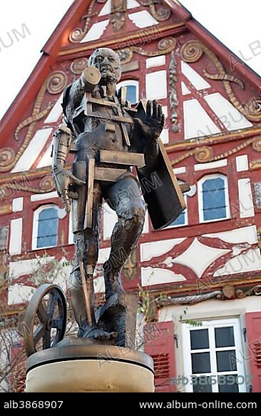 Statue of Goetz von Berlichingen by Gunther Stilling in front of the ornate half-timbered building of the Old Town Hall, Jagsthausen an der Jagst, Hohenlohe, Baden-Wuerttemberg, Germany, Europe, PublicGround, Europe.