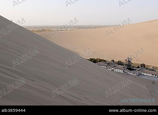 View from the sand dunes of the Gobi Desert on the Crescent Lake with Chinese Pagoda in Dunhuang, Silk Road, Gansu, China, Asia.