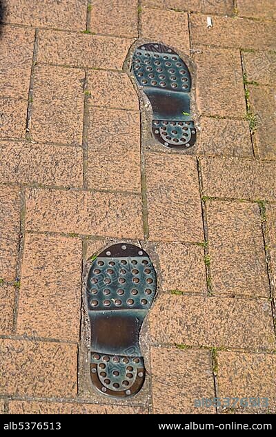 Thomas Tredyngton's footprints in the pavement by Catchcold Tower, medieval city walls, city centre, Southampton, Hampshire, England, United Kingdom, Europe.