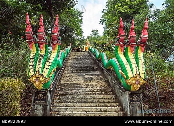 Three-headed Phaya Naga flanked the stairs up to the golden Buddha in Wat Phayam.