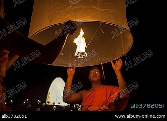 Monks releasing a Kongming lantern or sky lantern for luck during the Loi Krathong or Loy Gratong Festival, Chiang Mai, Northern Thailand, Thailand, Asia.