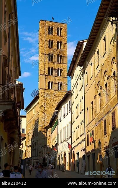 Arezzo, Tuscany, Italy. A group of people walking down a street next to tall buildings.