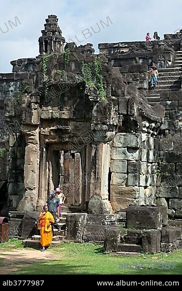 Buddhist monk and visitors at the entrance tower of Bakong Temple, Roluos Group, Angkor, Siem Reap, Cambodia, Southeast Asia, Asia.