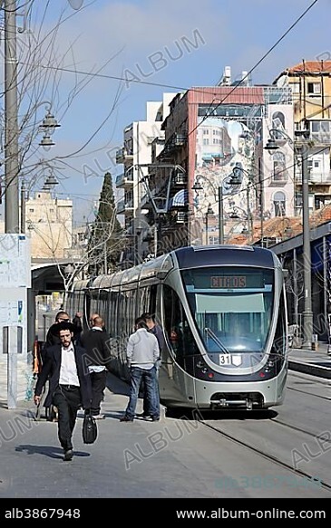 Street scene on the Jaffa Road with Orthodox Jews and a tram of the new tram line, light rail, and a mural of the new tram on a wall, Jerusalem, Israel, Middle East, Southwest Asia, Asia.