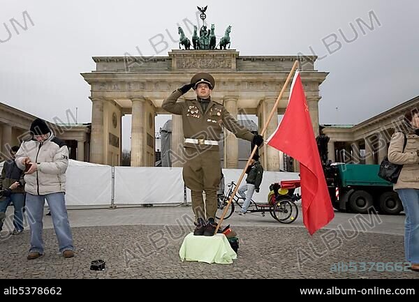 A man dressed up as a soviet army soldier poses in front of the Brandenburger Tor, Berlin.