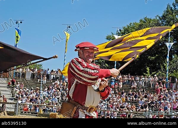 Standard bearer in mediaeval medieval costume with yellow black flag, knight festival Kaltenberger Ritterspiele, Kaltenberg, Upper Bavaria, Germany, Europe.