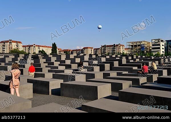 Visitors at the Holocaust Memorial designed by architect Peter Eisenman, Memorial to the Murdered Jews of Europe, Hi-Flyer balloon in the distance, Tiergarten, Berlin, Germany, Europe.