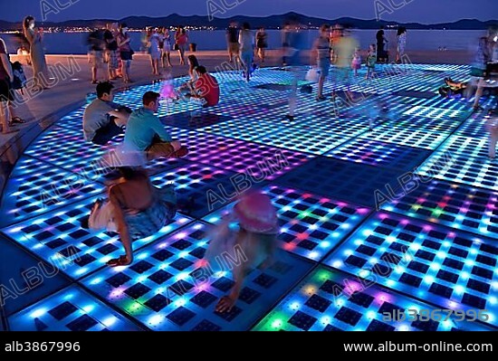 People at the Monument to the Sun, Pozdrav Suncu, by architect Nikole Bašica, at dusk, Zadar, Dalmatia, Croatia, Europe.