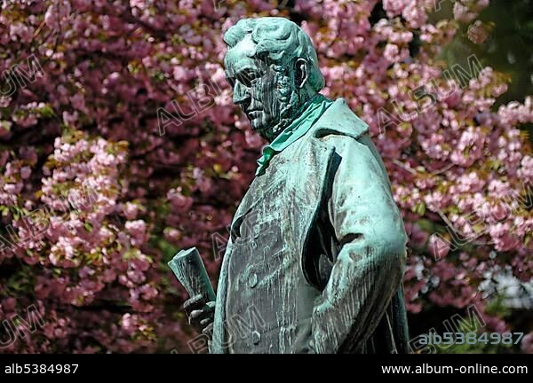 Monument to the chemist Johann Wilhelm Bunsen, 1811-1899, in the back a flowering almond trees, Anatomiegarten gardens, Hauptstrasse, Heidelberg, Baden-Wuerttemberg, Germany, Europe.