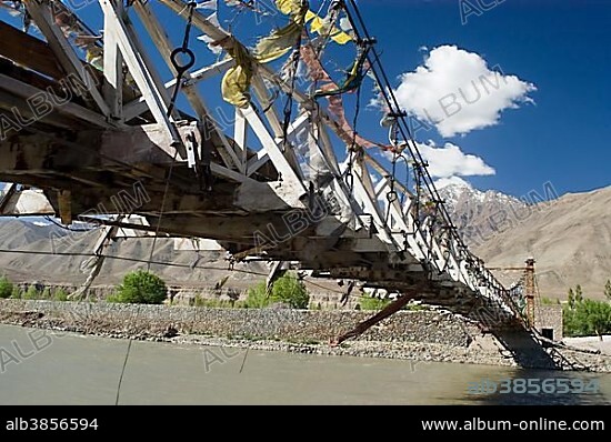 Swing bridge with prayer flags over the Indus river, Ladakh, Jammu and Kashmir, India, Asia.