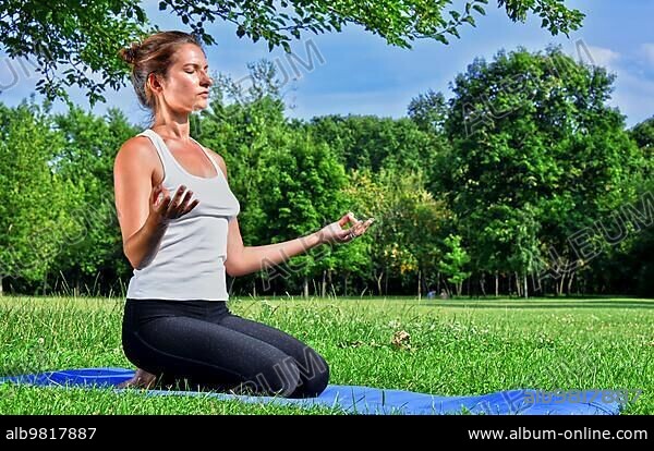 Young woman during yoga meditation in the park.