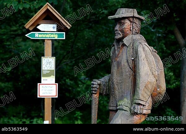 Wooden statue hiker with hat, sign Rennsteig, signpost to the Rennsteig, Rennsteig, high hiking trail, Thuringian Forest, Green Belt, border trail, former German-German border, Blankenstein, Saale-Orla district, Thuringia, Germany, Europe.
