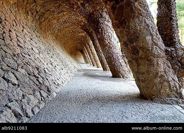 Barcelona. Catalonia. Spain. A colonnaded pathway in Park Guell, designed by Antoni Gaudi.