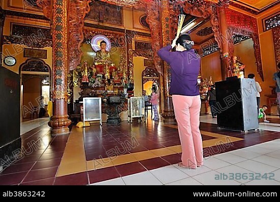 People praying in a Buddhist temple on the mountain of the black woman, Nui Ba Den, Tay Ninh, Vietnam, Asia.