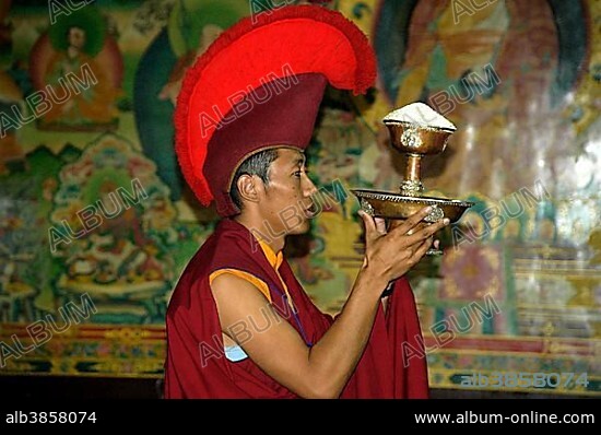 Portrait Buddhist monk of the red cap sect is wearing a specific red cap Bodhnath Stupa Kathmandu Nepal