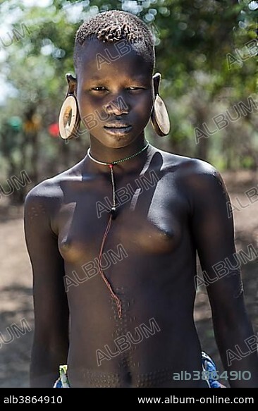Young girl with ornamental scars on her body, portrait, Mursi tribe, Southern Nations Nationalities and Peoples' Region, Ethiopia, Africa.