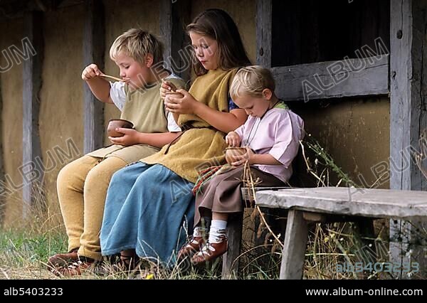 Children eating berries, outdoor museum "Hjemsted Oldtidspark", a village of the Iron Age, Skaerbaek, Danmark.