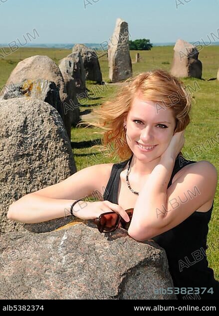 Redhaired woman at the Ale's Stones or Ales stenar near KÃ¥seberga, Sweden, Europe.