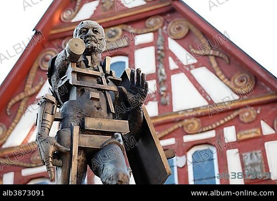 Statue of Goetz von Berlichingen by Gunther Stilling in front of the ornate half-timbered building of the Old Town Hall, Jagsthausen an der Jagst, Hohenlohe, Baden-Wuerttemberg, Germany, Europe, PublicGround, Europe.