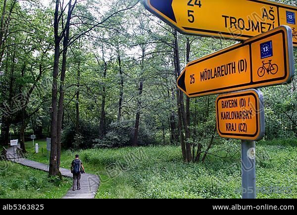 Signpost in the border triangle, man with backpack, man at the border Germany, Czech Republic, Green Belt, column path, border path, inner German border installation, hiking trail, Bavaria, Saxony, Czech Republic, Germany, Czech Republic, Europe.