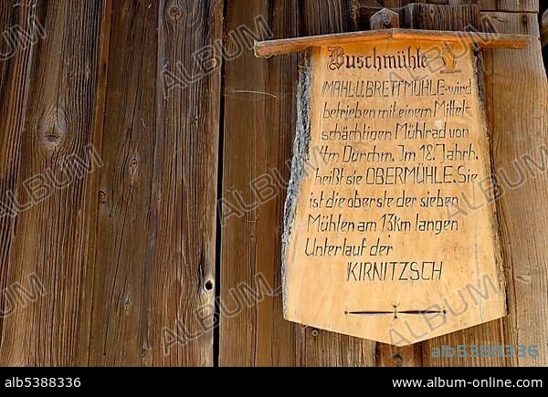 Wooden sign with information on the Buschmuehle mill on wooden wall, Kirnitzschtal valley, Nationalpark Saechsische Schweiz National Park Saxon Switzerland, Saxony, Germany, Europe.
