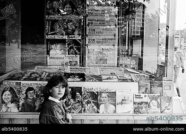 Girl in front of a kiosk of the Post-Zeitung Vertriebes PZV of the GDR in Dunkerstrasse, the assortment consists of newspapers and magazines of the GDR and other socialist states, East Berlin, District of Prenzlauer Berg, GDR, Germany, Europe.