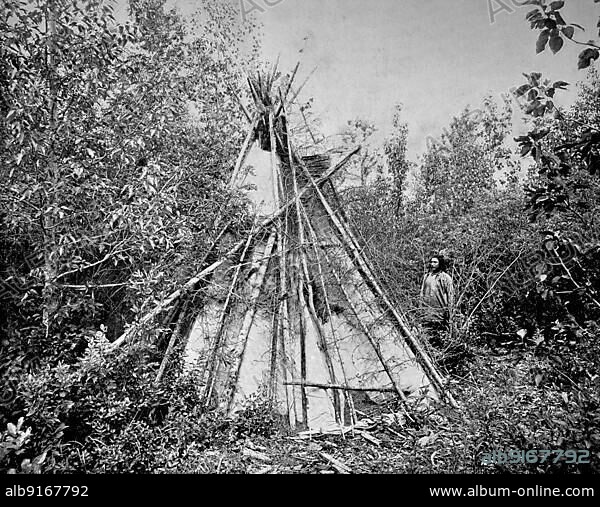 Crow or Absaroka Indian Chief standing in front of the tent of his woman's funeral court, ca 1880, America, Historic, digitally restored reproduction of a 19th century photographic original.