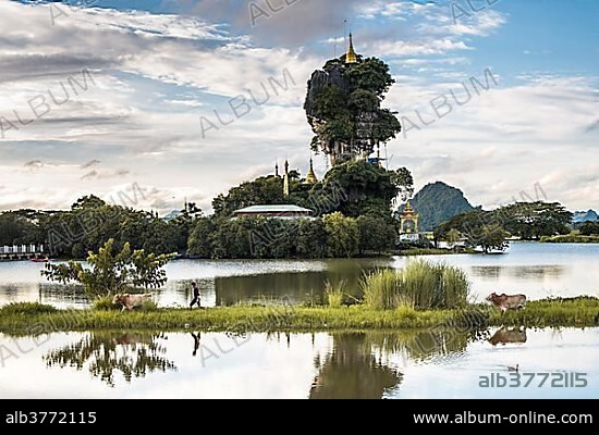 Kyauk Kalap pagoda on a rock, monastery, boy with zebu, reflected in the lake, Hpa-an, Karen State, Myanmar, Myanmar, Asia *** IMPORTANT: Exclusive usage, calendar cover, duration Jan. 1, 2018 - Dec. 31, 2018, territory DEU, AUT, CHE ***.