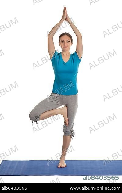 Yoga, young beautiful woman yoga instructor doing Tree pose asana (Vrikshasana) exercise isolated on white background.