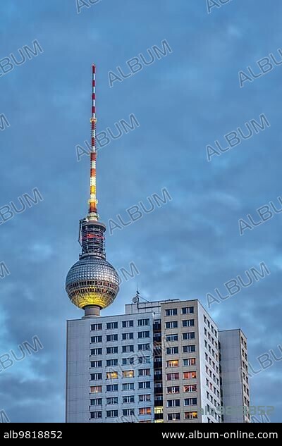 The famous Berlin TV tower at dusk with a typical GDR prefabricated building.