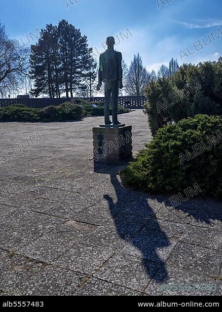 Feldscheune Isenschnibbe Gardelegen Memorial, bronze sculpture "The Resistance Fighter" by sculptor Joachim Sendler from 1971 in front of a wall remnant of the barn where 1016 concentration camp prisoners from many European countries were murdered on 13 April 1945, Gardelegen, Saxony-Anhalt, Germany, Europe.