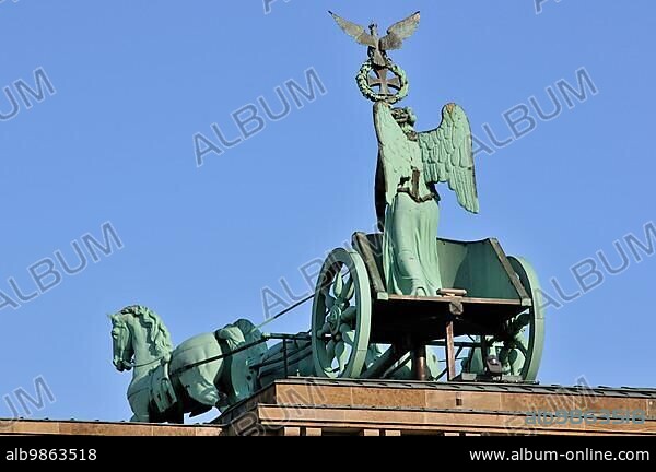 Atop the Brandenburg gate is the Quadriga, a chariot drawn by four horses driven by Victoria, the Roman goddess of victory. The Brandenburg Gate is crowned by a five-metre-high copper sculpture made by Johann Gottfried Schadow. It depicts the winged goddess of victory Victoria steering a chariot (quadriga) drawn by four horses into the city.