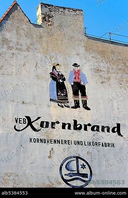 House wall with liquor advertising from the GDR era, VEB Kornbrand Schnapps, mural painting of a peasant couple, Rostock, Mecklenburg-Western Pomerania, Germany, Europe.