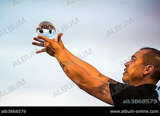 Juggler with crystal ball, Kulturufer, Festival with street artists, Friedrichshafen, Lake Constance, Baden-Württemberg, Germany, Europe.
