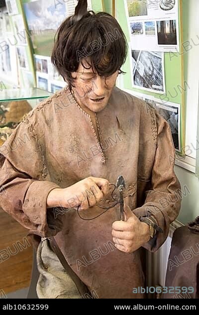 Mannequin model of male Mesolithic hunter attaching flint arrow head, Amesbury History Centre, Wiltshire, England, UK.