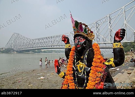 Kali statue at the banks of river Hooghly, Howrah Bridge at back, Kolkata, West Bengal, India, Asia.