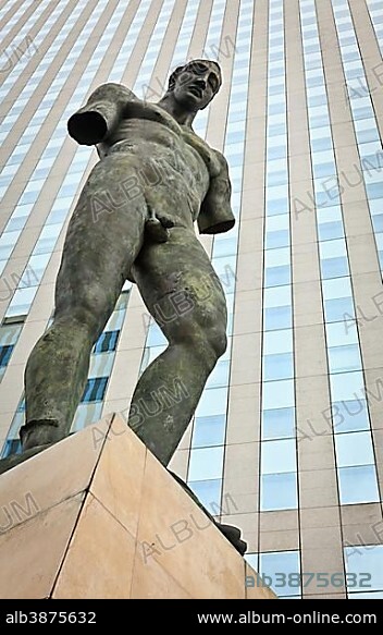 Sculpture of a man in front of a glass building in the business district of La Défense, Paris, France, Europe.