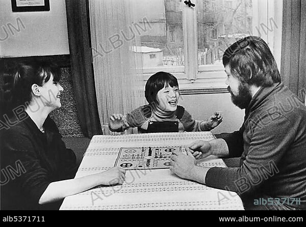 Family playing the Mensch-aergere-dich-nicht board game, East Germany, Europe, circa 1975.