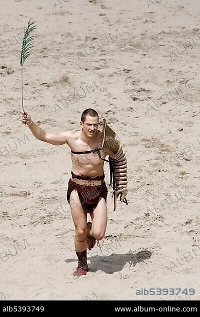 Victorious Retiarius running a lap of honor waving a palm frond, a gladiator fight, exhibition fight, Familia Gladiatoria Pulli Cornicinis by Marcus Junkelmann, Roemerfest festival 2012, stadium of the Archaeologischer Park Xanten outdoor museum, Lower Rhine region, North Rhine-Westphalia, Germany, Europe.