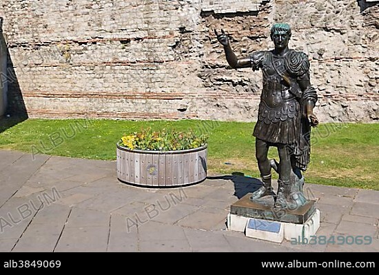Statue of Trajan in front of a section of the Roman wall, Tower Hill, City of London, London, England, United Kingdom, Europe.